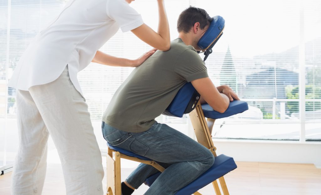 Man in massage therapist chair