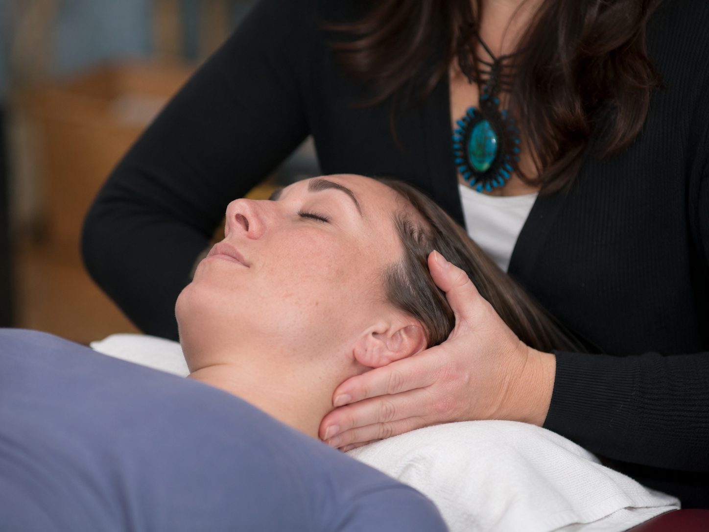 Gentle concussion recovery massage focusing on the neck and shoulders in calm, dim lighting at Carpe Diem Massage Therapy in London, Ontario
