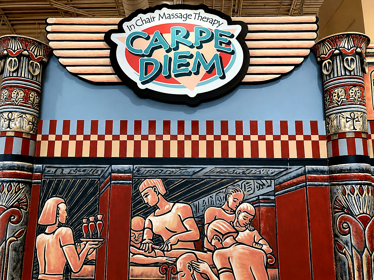 Hand-painted Egyptian mural of figures giving massage, framed by lotus columns